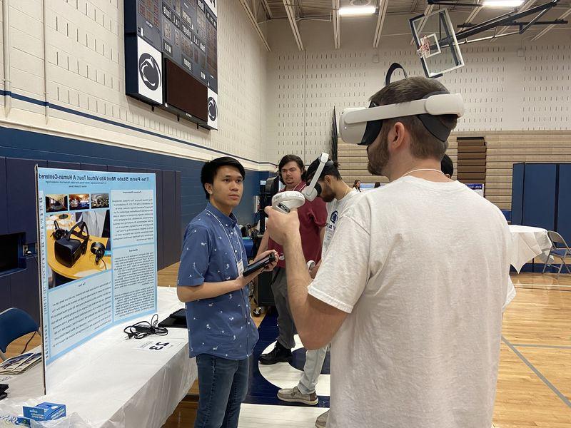 一名学生戴着虚拟现实耳机，另一名学生在旁边观看.